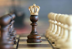 a chess piece with a royal crown atop it's head